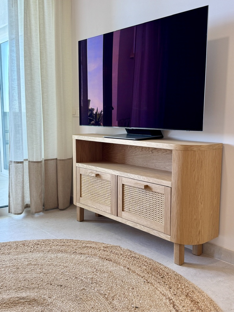 Mueble de TV en madera con puertas de ratán natural